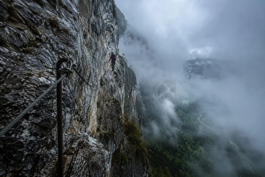 Ambiance brumeuse et pluvieuse sur une via ferrata en falaise calcaire