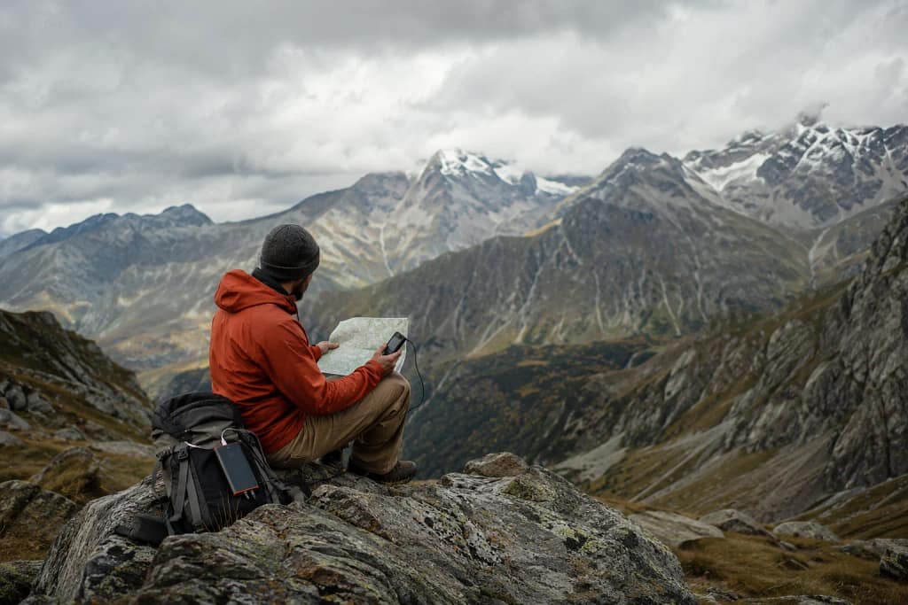Randonneur vérifiant une carte papier et un GPS pour plus de sécurité en montagne