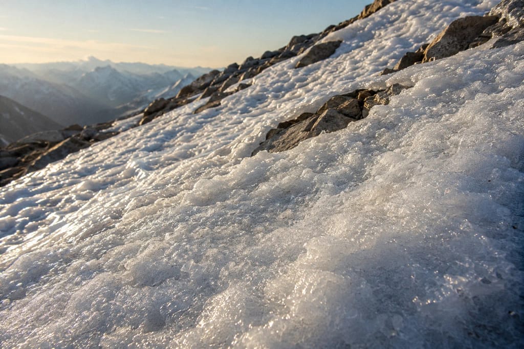 Texture de névé persistant sur une pente en altitude en été