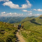 Panorama estival des Pyrénées avec sentier de randonnée serpentant à travers les alpages