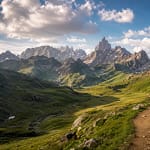 Panorama estival sur les montagnes des Pyrénées avec sentier de randonnée et sommets rocheux