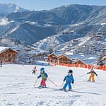 Scène de ski dans un village alpin avec chalet en bois