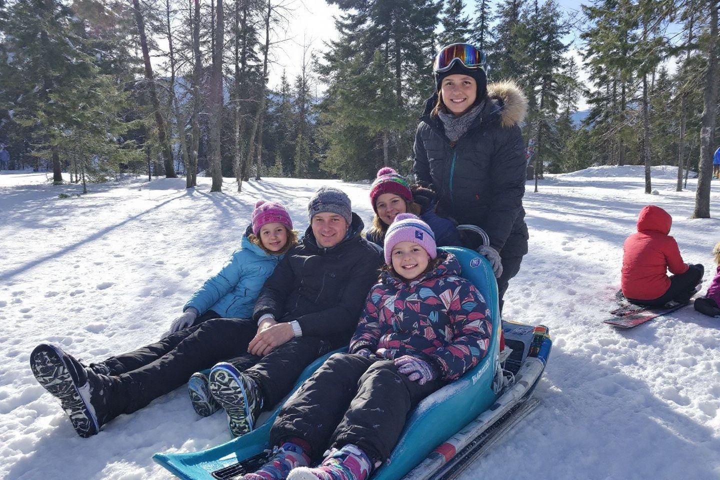 Famille en tenue d'hiver profitant d'une journée de neige dans la forêt